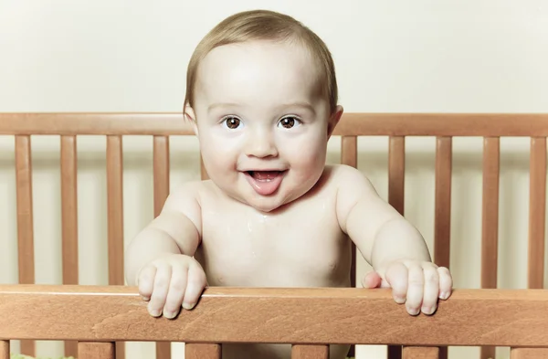 Funny little baby with beautiful standing in a round white crib — Stock Photo, Image