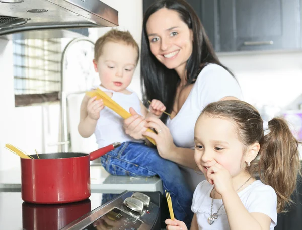 Una familia cocina pasta dentro de la cocina — Foto de Stock