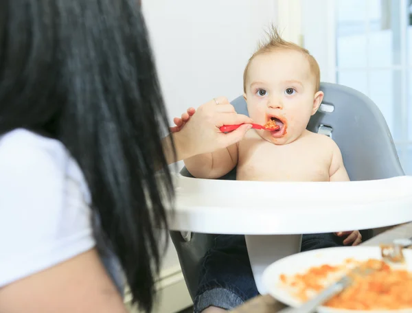 Mother feeding hungry six month old baby solid food — Stock Photo, Image