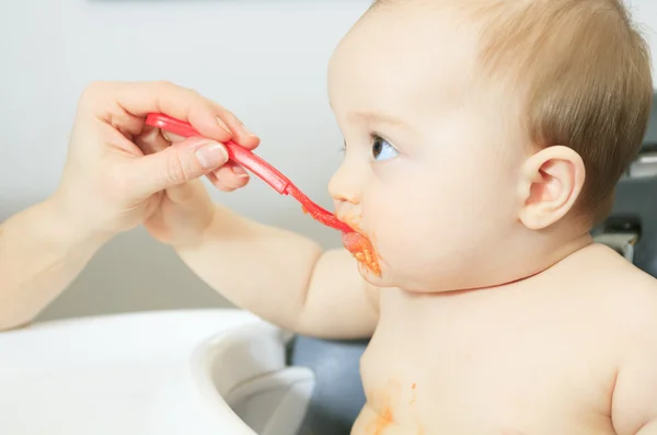 Moeder voederen honger zes maanden oude baby vast voedsel — Stockfoto