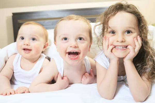 Familia joven descansando juntos en la cama de los padres —  Fotos de Stock