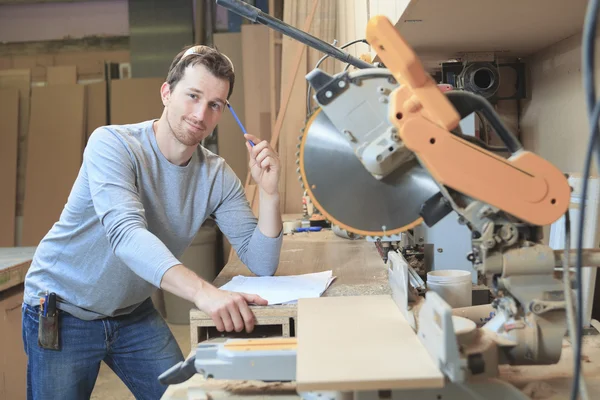 An adult carpenter measuring wood with ruler at table in worksho — Stock Photo, Image