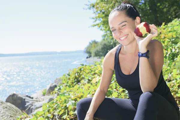Una donna sportiva felice con una mela — Foto Stock