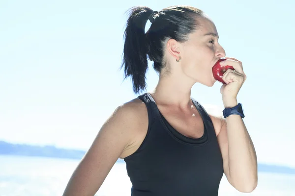 Una donna sportiva felice con una mela — Foto Stock