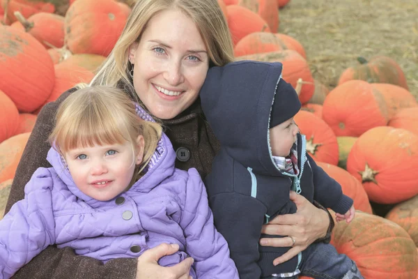 An attractive Mother with kids Portrait in Pumpkin — Stock Photo, Image