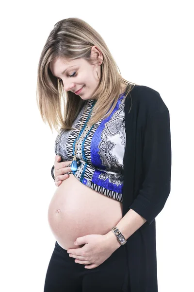 Una donna incinta accarezza la pancia su sfondo bianco — Foto Stock