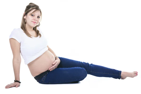 Uma mulher grávida acariciando sua barriga sobre fundo branco — Fotografia de Stock