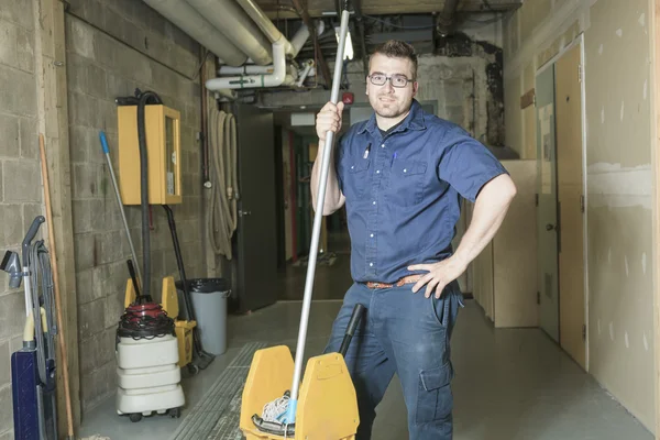 A serviceman who cleaning the floor with his mop