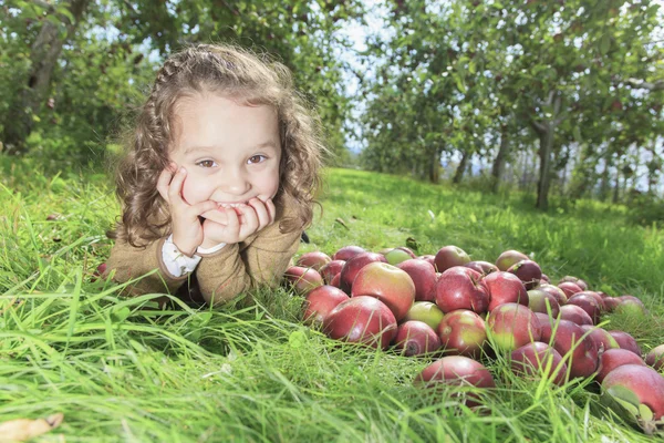 Cute little preschooler girl eating an apple on beautiful autumn — Stock Photo, Image