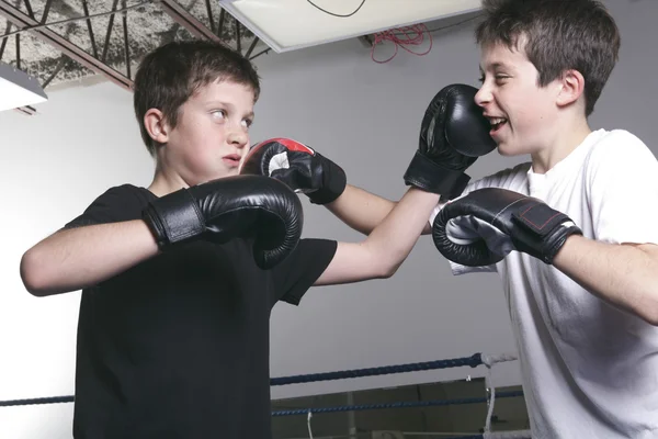 Menino com luvas de boxe preto luta com é irmão — Fotografia de Stock