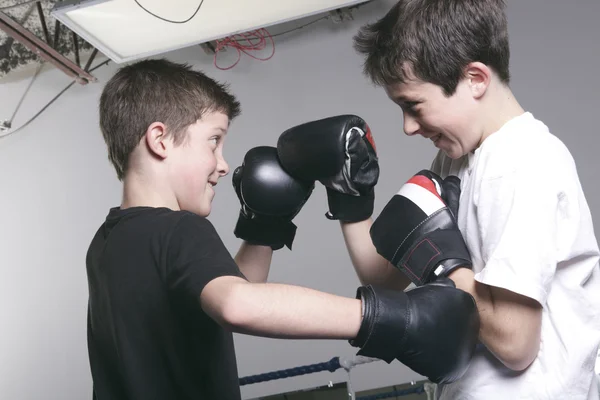 Menino com luvas de boxe preto luta com é irmão — Fotografia de Stock