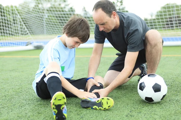 Un jeune footballeur avec un ballon sur le terrain — Photo