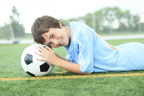 Een jonge voetballer met bal op het veld — Stockfoto