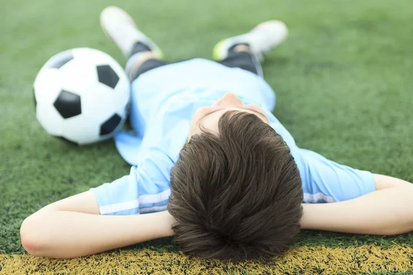 Молодой футболист с мячом на поле — стоковое фото