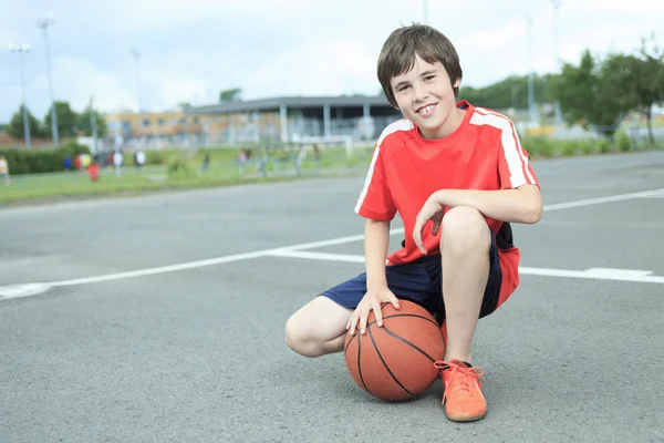 Ung pojke i basket som har roligt — Stockfoto