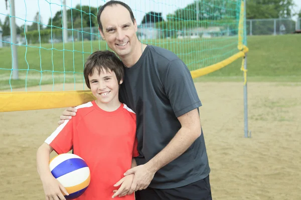 Portrait of happy family holding volleyball outside — Stock Photo, Image