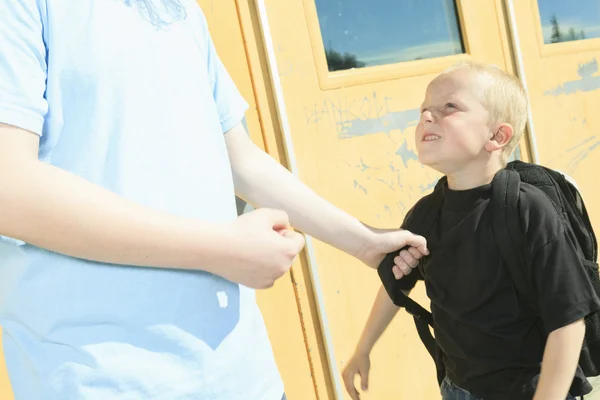 Un garçon intimidant un autre dans une aire de jeux de l'école — Photo