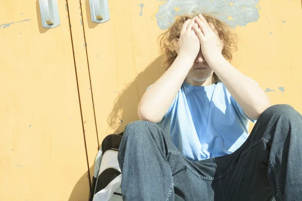 Грустный одинокий мальчик на школьной площадке — стоковое фото