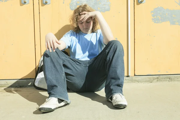 Triste chico solitario en el patio de la escuela —  Fotos de Stock