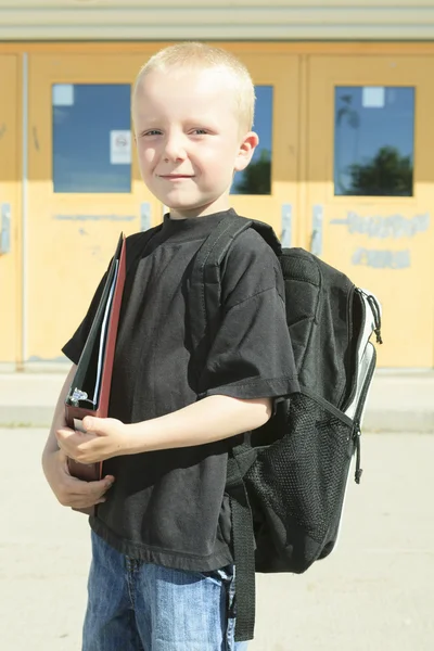 Un garçon sur le terrain de jeu de son école avec un backpak — Photo