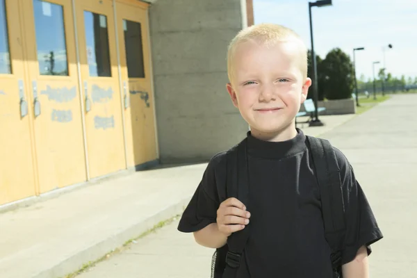 Un garçon sur le terrain de jeu de son école avec un backpak — Photo