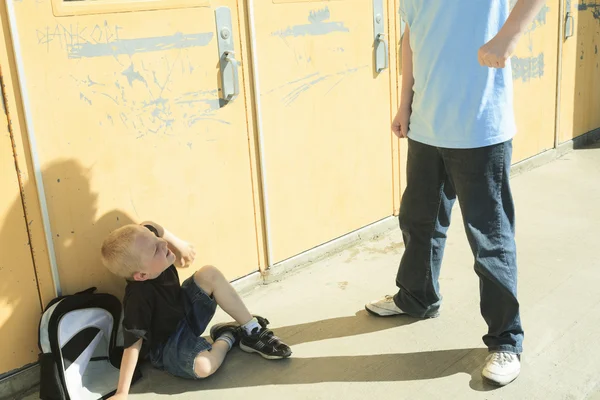 A boy bullying another in school playground — Stock Photo, Image