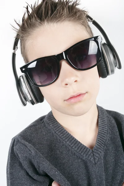 Young boy wearing headphones listening music in studio. Stock Photo
