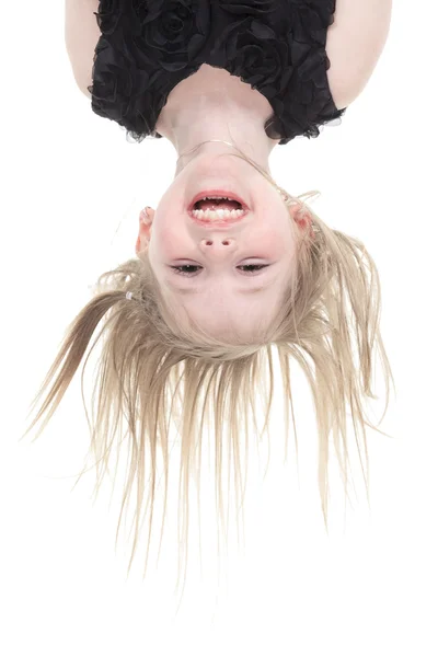 Happy little girl hanging upside down isolated on white — Stock Photo, Image