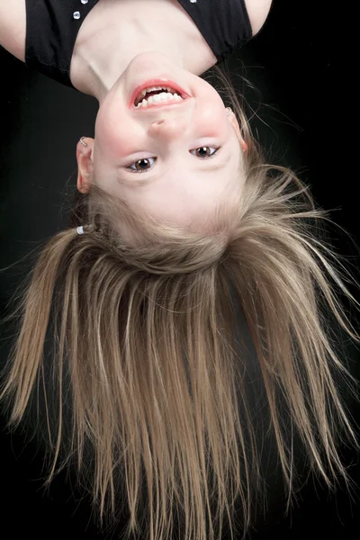 Menina feliz pendurado de cabeça para baixo isolado no branco — Fotografia de Stock