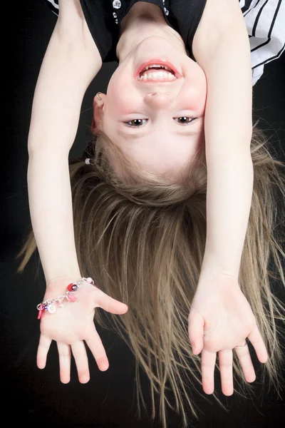 Menina feliz pendurado de cabeça para baixo isolado no branco — Fotografia de Stock