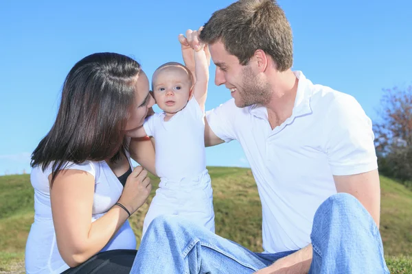 Una giovane famiglia felice con il bambino all'aperto — Foto Stock