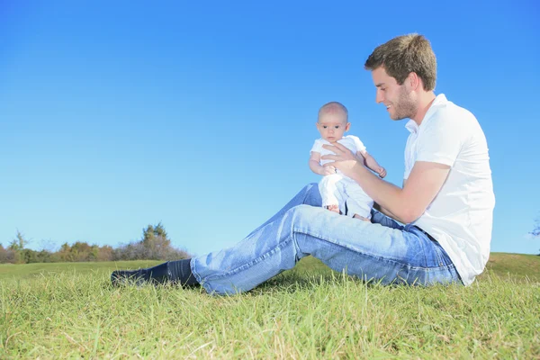 En glad far och hans lille son i fältet sommaren — Stockfoto