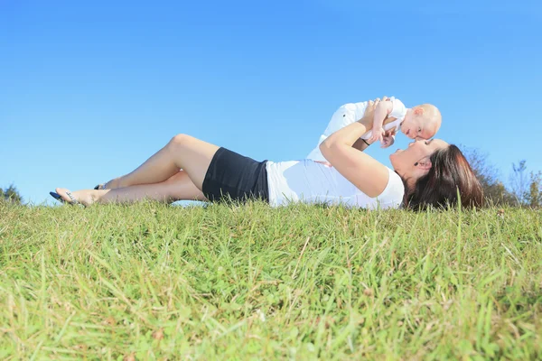 En glad mamma och hennes lilla son i fältet sommaren — Stockfoto