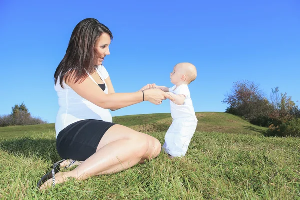 En glad mamma och hennes lilla son i fältet sommaren — Stockfoto