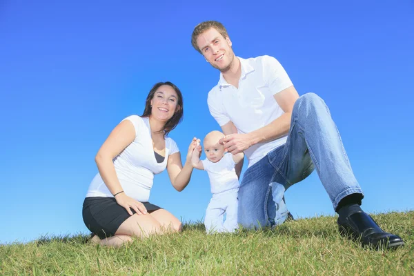 Una giovane famiglia felice con il bambino all'aperto — Foto Stock