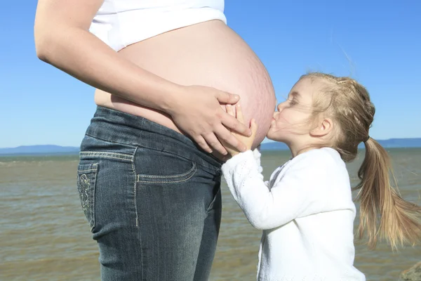 Una mujer embarazada feliz fuera con es un niño —  Fotos de Stock