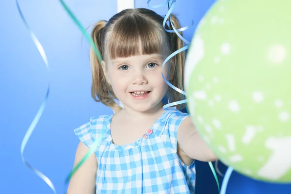 Ein kleines Mädchen spielt mit grünem Luftballon — Stockfoto
