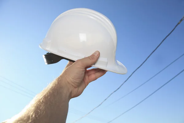 Una mano sosteniendo un casco de capataz sobre el cielo —  Fotos de Stock