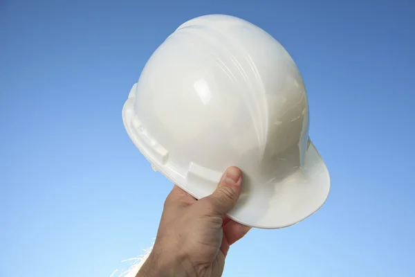 Una mano che tiene un casco da caposquadra sopra il cielo — Foto Stock