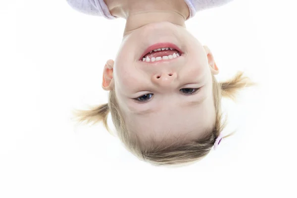 Funny little girl hanging upside down on white — Stock Photo, Image