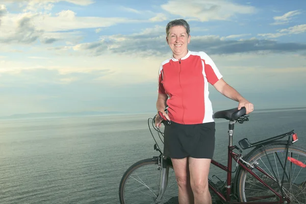 En äldre man och en kvinna på cykel på solnedgången. — Stockfoto