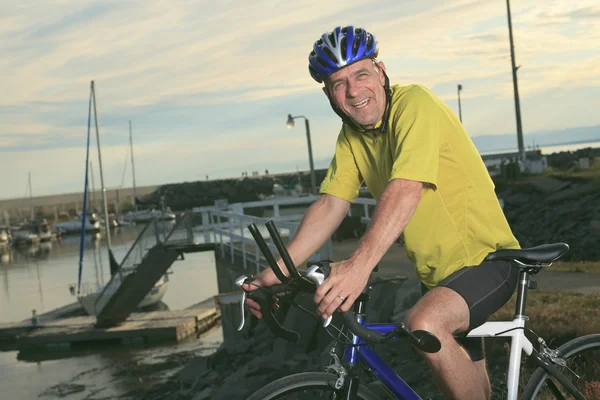 A senior man on bike at the sunset. — Stock Photo, Image