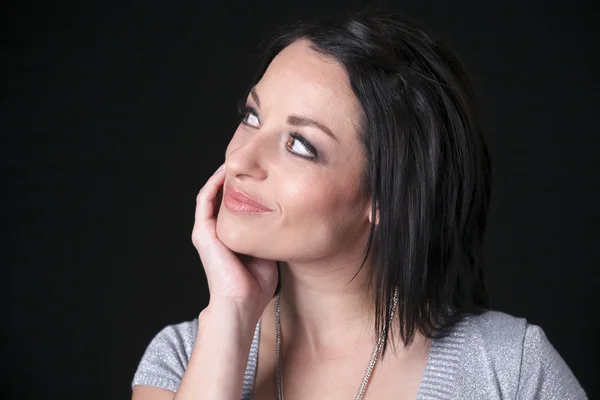 A thinking woman over a dark background — Stock Photo, Image