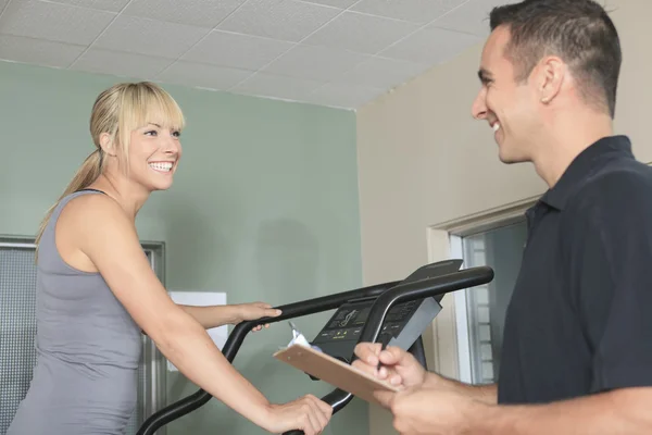 Ginásio mulher personal trainer homem com equipamento de treinamento de peso — Fotografia de Stock