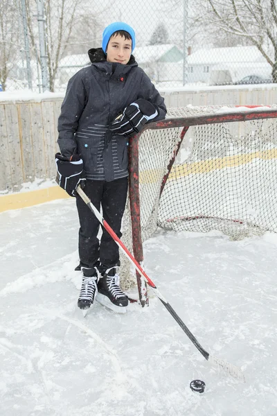 Teenager spielt draußen auf einer Eisbahn Hockey. — Stockfoto