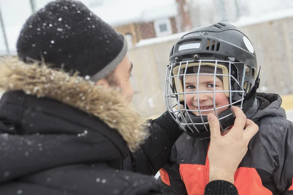 A family playing at the skating rink in winter. — Stock Photo, Image