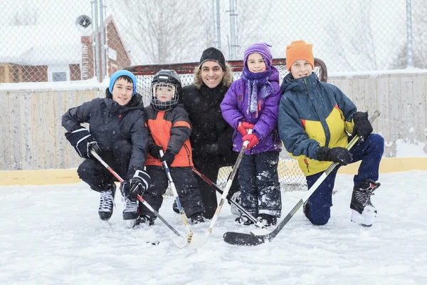 Uma família jogando no ringue de patinação no inverno . — Fotografia de Stock