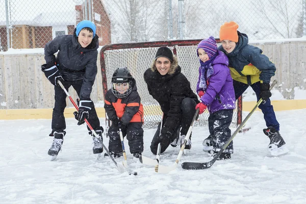 Uma família jogando no ringue de patinação no inverno . — Fotografia de Stock