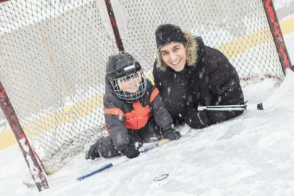 Uma família jogando no ringue de patinação no inverno . — Fotografia de Stock