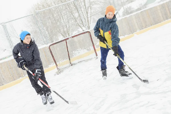 Adolescente jugando hockey fuera en una pista de hielo . —  Fotos de Stock